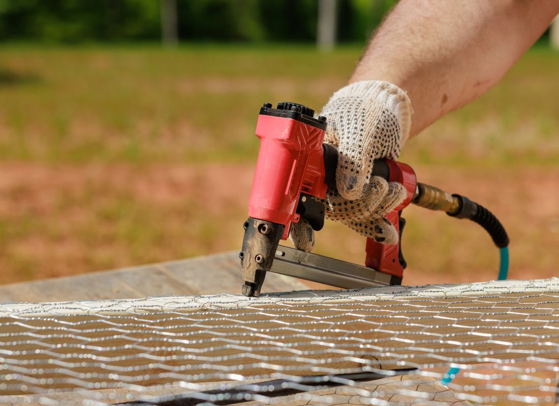 osoba pravi kavez za koke koristeći mrežu i kroisti pištolj za eksere