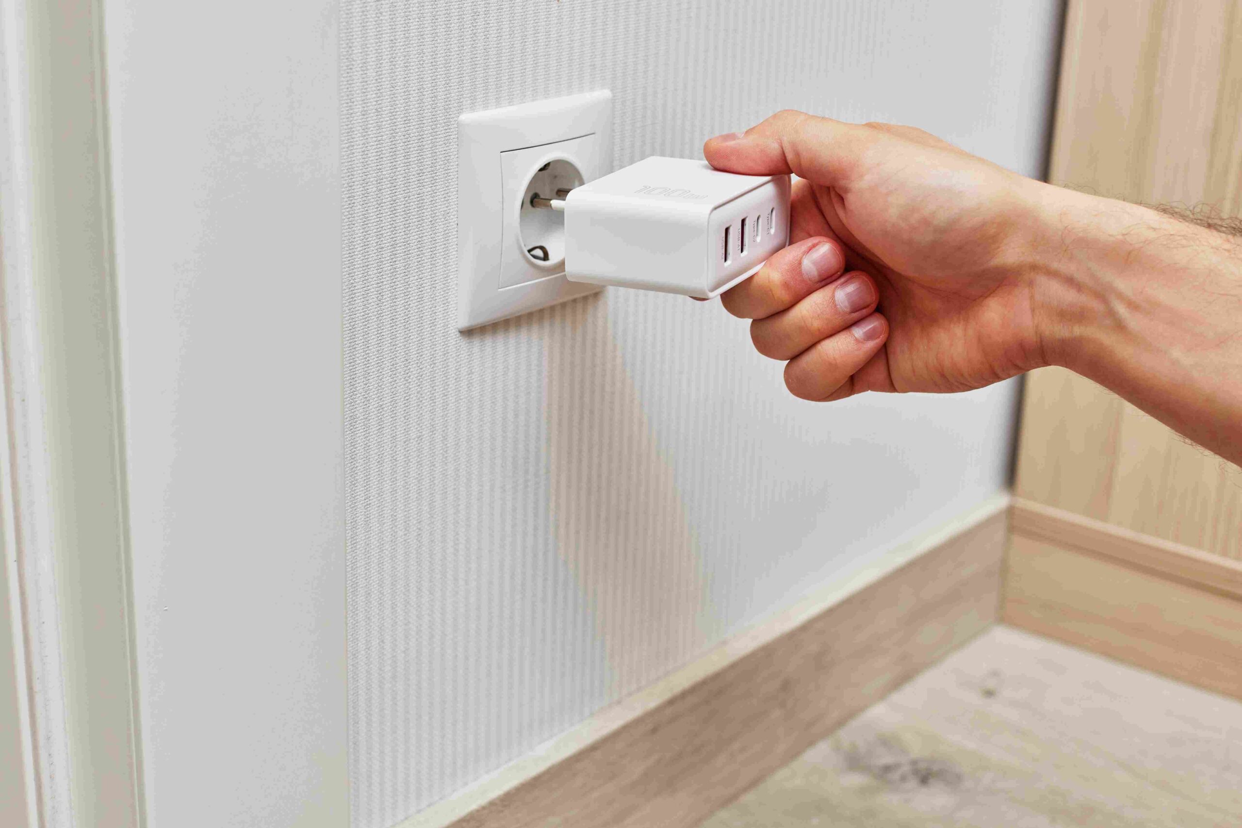 Ruka uključuje punjač u zidnu utičnicu