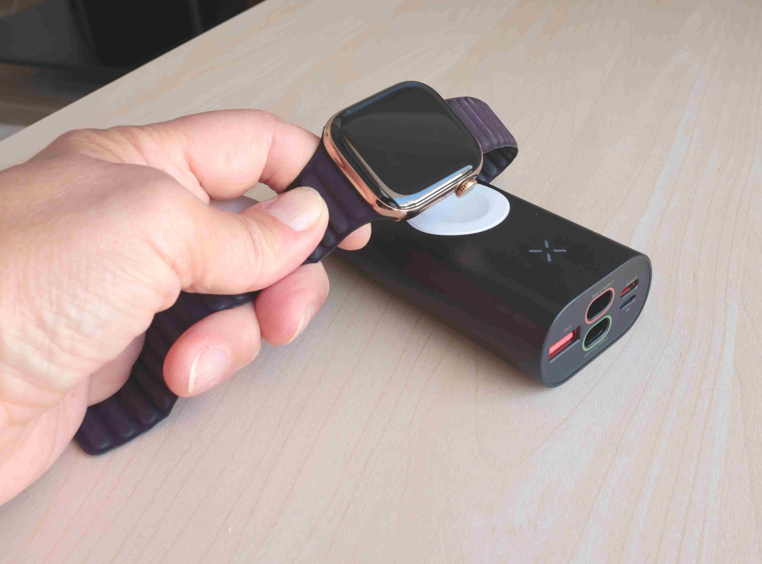 Pametni sat postavljen na bežični punjač povezan sa power bank uređajem