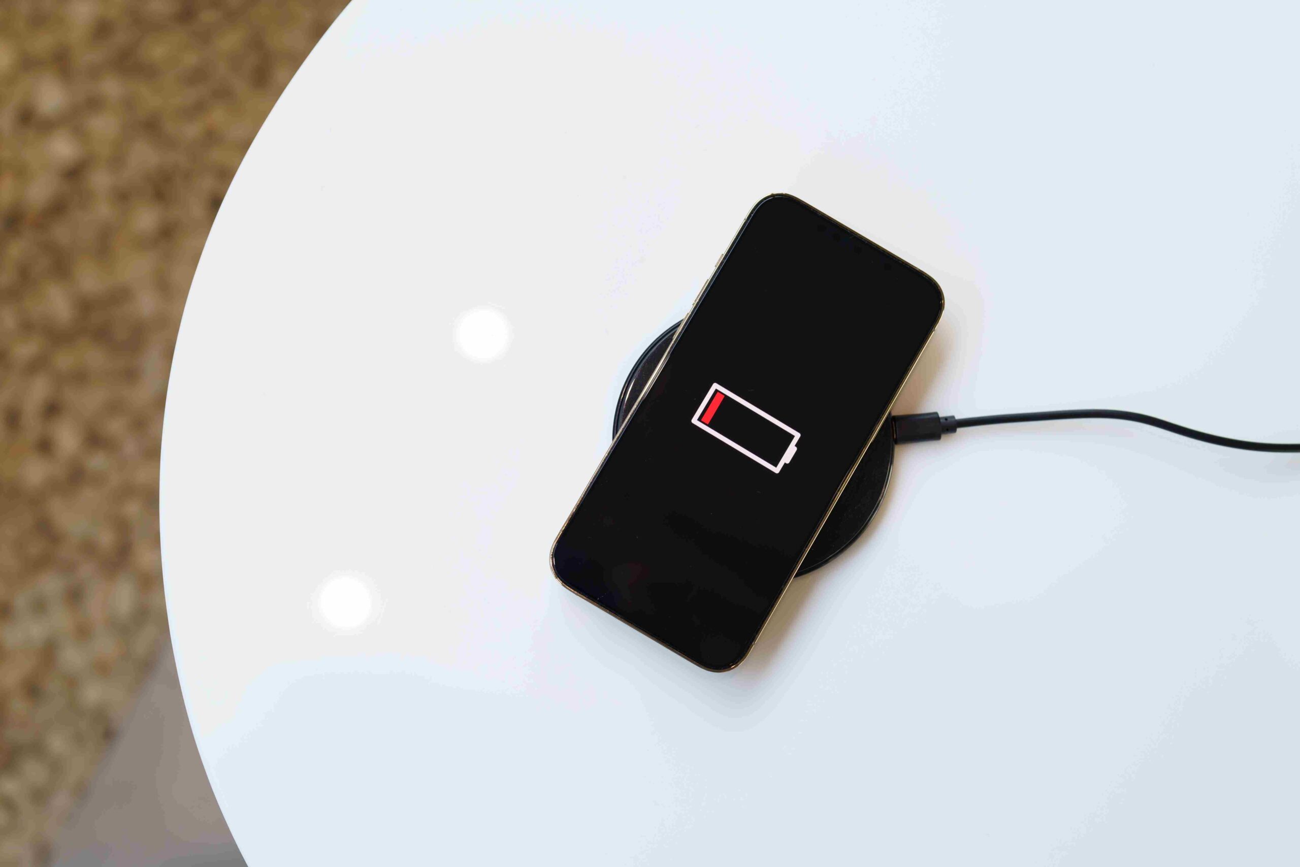 Pametni telefon sa niskim nivoom baterije postavljen na bežični punjač